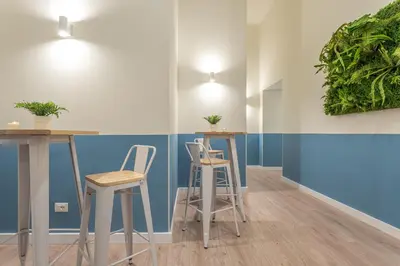 a room with two stools and a table with plants on the wall at Vittoria Garden Suites in Rome