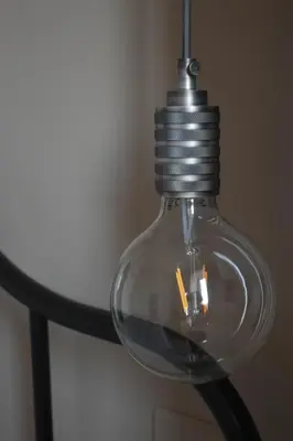a glass light bulb hanging from a ceiling at Trastevere St Ariabianca House in Rome