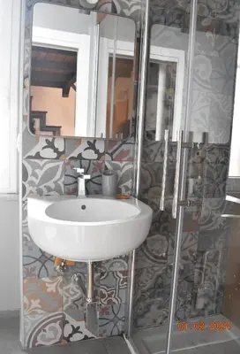 a bathroom with a white sink and a mirror at Trastevere St Ariabianca House in Rome