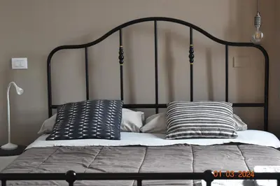 a black metal bed with two pillows on it at Trastevere St Ariabianca House in Rome