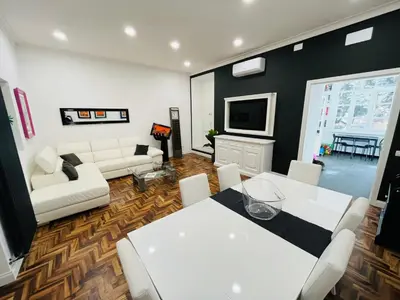 a living room with a white table and white chairs at New Prati Luxury Apartment in Rome