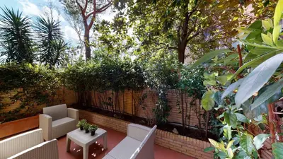 a patio with two chairs and a table and a fence at Pietra Papa Suite 99 in Rome