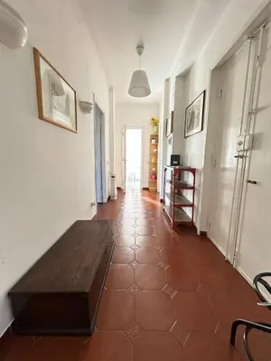 a living room with a wooden table on a tile floor at Trastevere Rome's Heart Charming & Cozy appartment 3 in Rome