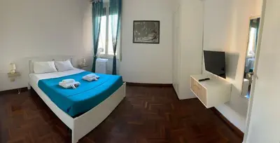 a bedroom with a bed with blue sheets and a television at Trastevere Rome's Heart Charming & Cozy appartment 3 in Rome