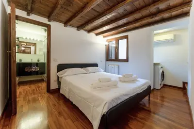 a bedroom with a large bed with two towels on it at Ciambella Arch Apartment for 6 people @Largo Argentina in Rome