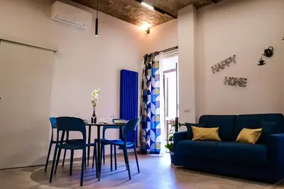 a living room with a table and a blue couch at Lele Rooms Termini in Rome