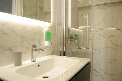 a bathroom with a sink and a glass shower at Lele Rooms Termini in Rome