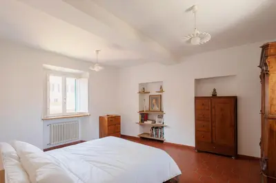 a bedroom with a large white bed and a window at Quiet apartment in the heart of Trastevere in Rome
