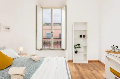 a white room with a large window and a bed at Bell Appartamento in Rome