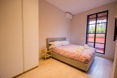 a small bedroom with a bed and a window at Pelliccia 11 Trastevere Penthouse in Rome