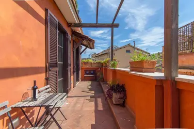 a patio with a wooden bench on a building at Pelliccia 11 Trastevere Penthouse in Rome