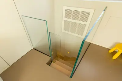 a glass elevator with a staircase in a room at Pelliccia 11 Trastevere Penthouse in Rome