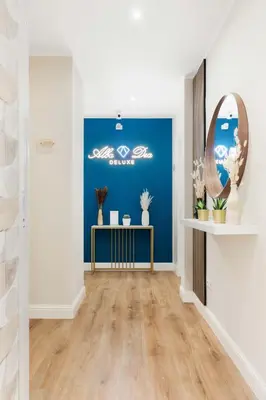 a hallway with a blue wall and a table with a mirror at AlbaDea Deluxe in Rome
