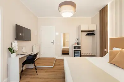 a bedroom with a bed and a desk and a chair at AlbaDea Deluxe in Rome