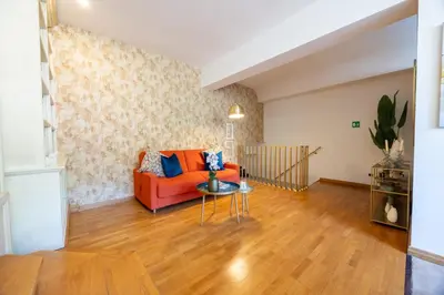 a living room with an orange couch and a table at MB SUITES Margutta in Rome