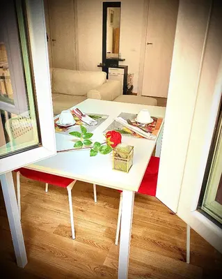 a small white table with a rose on top of it at I-LARI Apartment in Rome