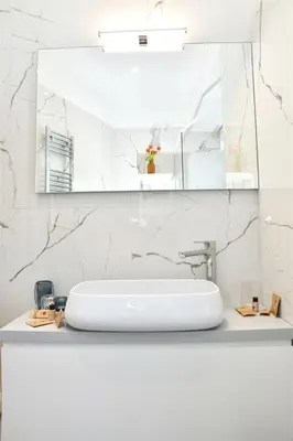a white bathroom with a sink and a mirror at Roma Clodio Holiday in Rome