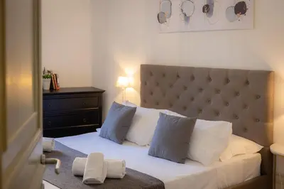 a bedroom with a bed with white sheets and pillows at Angelico By Rental in Rome in Rome