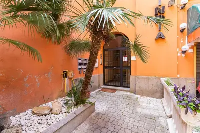 an orange building with a palm tree in front of it at AM House Colosseo in Rome