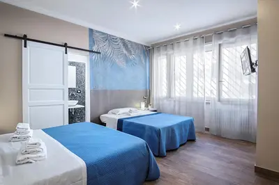 two beds in a room with blue sheets at Venturi Comfort in Rome