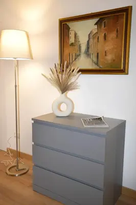 a dresser with a lamp and a painting on the wall at Fidia Palace Claudia's apartment Colosseo in Rome
