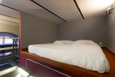 a bed with white sheets and pillows in a room at Trastevere Loft in Rome