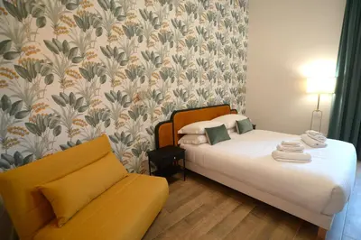 a bedroom with two beds and a yellow couch at San Cosimato 40 guesthouse in Rome