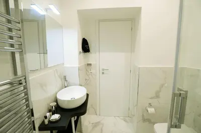 a white bathroom with a toilet and a shower at San Cosimato 40 guesthouse in Rome