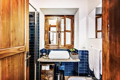 a bathroom with blue tiles and a sink at MAYA RHOME TRASTEVERE in Rome