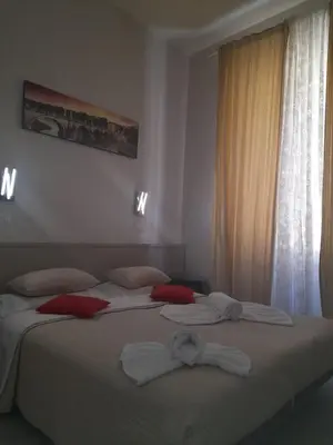 a bedroom with a large bed with red and white pillows at GUEST HOUSE FIDARDO in Rome