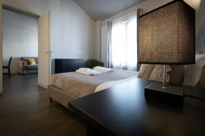 a bedroom with a bed and a table with a lamp at HT Luxury Altare della Patria in Rome