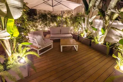 a patio with chairs and an umbrella and plants at The Central View - DolceVite in Rome