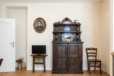 a grandfather clock in a living room with a television at Elegante grande appartamento con 4 stanze - Vaticano e centro Roma in Rome