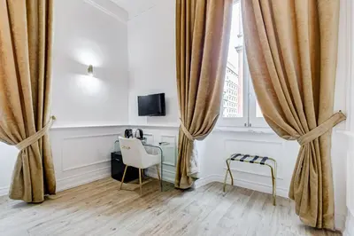 a room with a desk and a window with curtains at Monti Suites Cavour in Rome