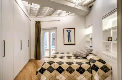 a bedroom with a bed with a checkered blanket at suity I cozy leutari 23 in Rome