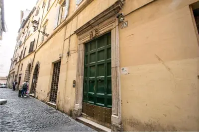 a green door on the side of a building at suity I cozy leutari 23 in Rome