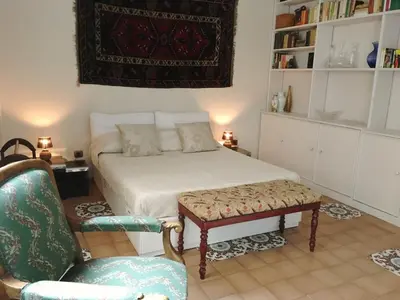 a bedroom with a bed and a chair and a couch at Foscari Holiday House in Rome