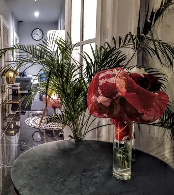 a vase with a flower on a table in a room at NiK in Rome