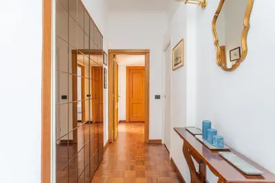 a hallway with a wooden table and a mirror at Modern 2BDR apartment vibrant Prati neighborhood in Rome