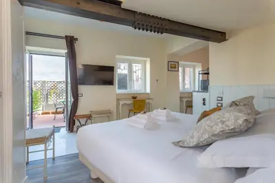 a bedroom with a large white bed and a balcony at the B rooftop apartment in Rome
