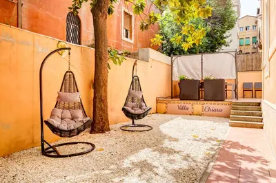 two wicker swings sitting next to a tree at Villa Chiara - a new Luxury Star is born in Rome! in Rome