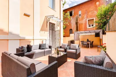 an outdoor patio with wicker furniture and a table at Villa Chiara - a new Luxury Star is born in Rome! in Rome