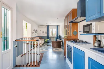 a kitchen with blue cabinets and a spiral staircase at Elizabeth Penthouse, Charmy Apartment in Little London 10 Min From the Center in Rome