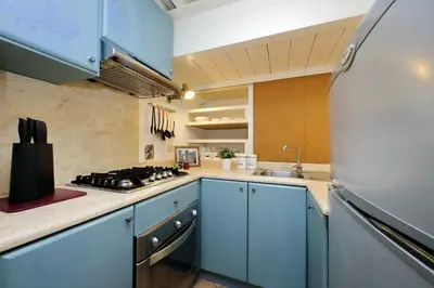 a kitchen with blue cabinets and a stainless steel refrigerator at Borgo Comfortable Loft in Rome