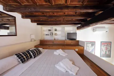 a bedroom with a large bed and a tv at Borgo Comfortable Loft in Rome